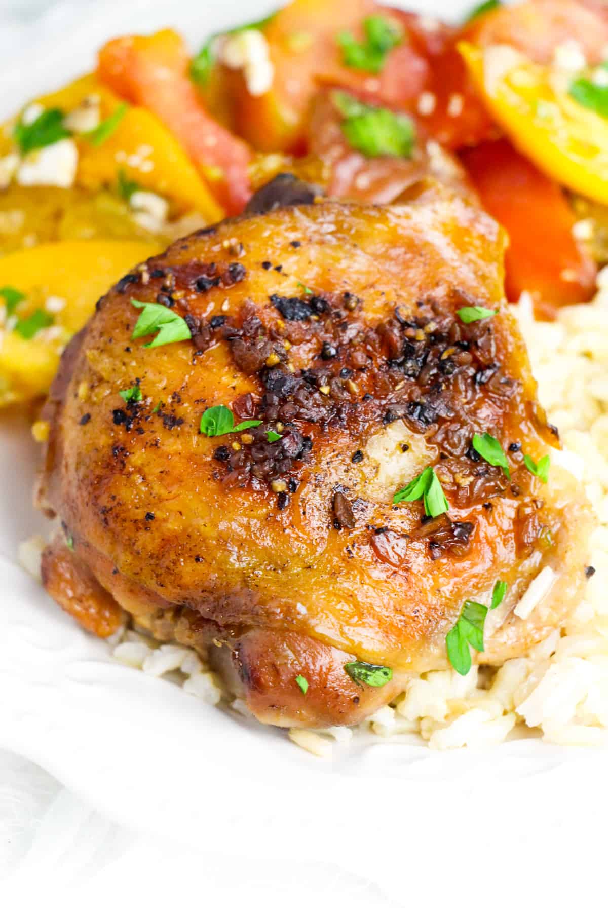 Crockpot brown sugar garlic chicken thigh served over rice with tomato salad 