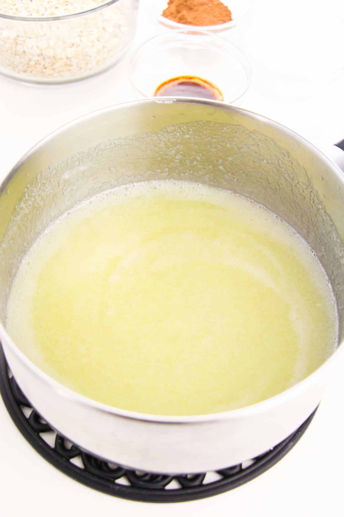 Butter, milk, and white sugar in saucepan with additional ingredients in background