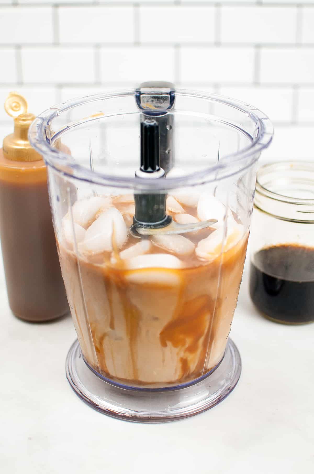 blender with coffee, milk, caramel, sugar, and ice