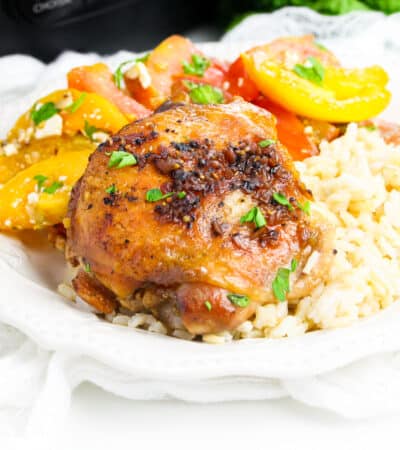 Brown sugar garlic chicken thigh made in the crockpot served over rice with tomato salad