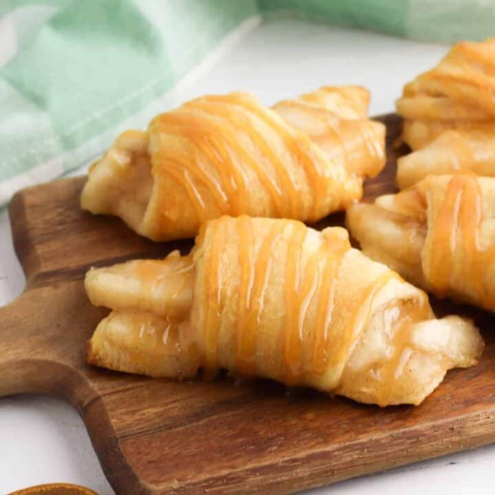Crescent rolls filled with apple pie filling and drizzles with caramel sauce