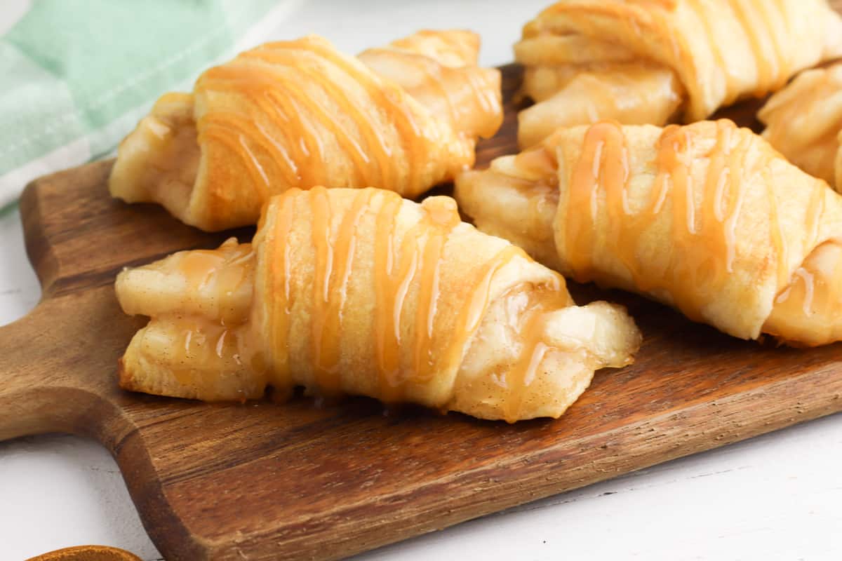 Crescent rolls filled with apple pie filling and drizzles with caramel sauce