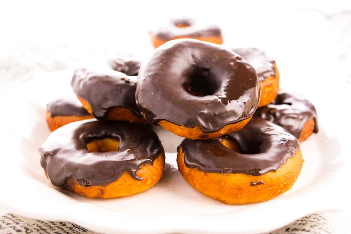 Chocolate frosted doughnuts on white plate