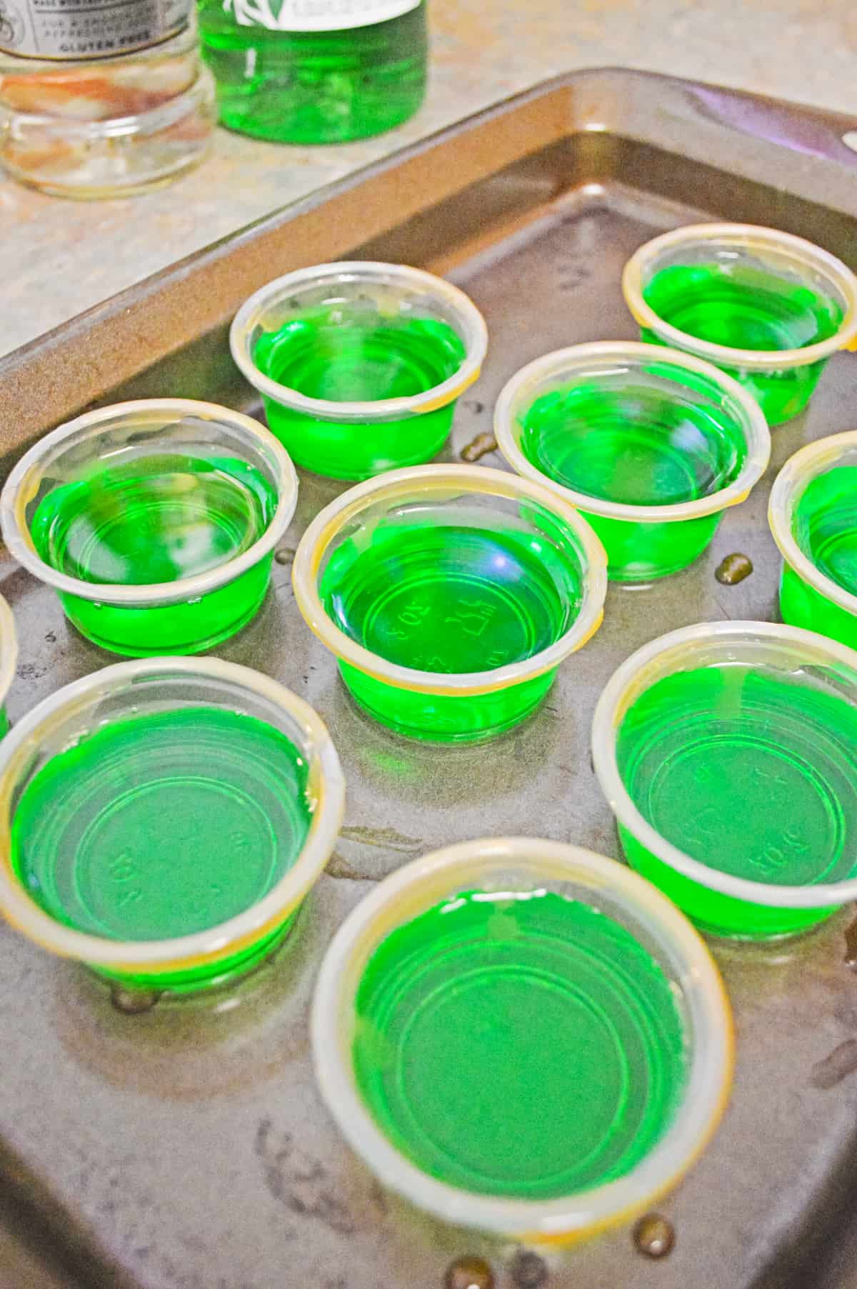 green apple jello shots on baking sheet
