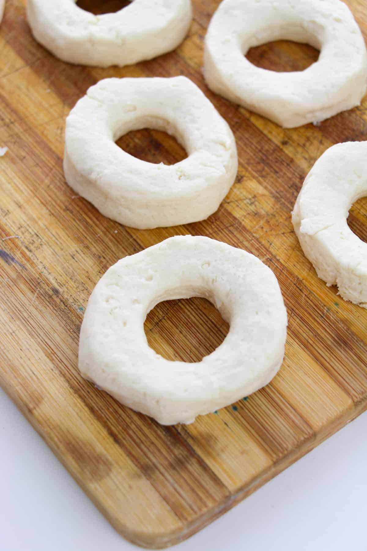 Canned biscuit dough with hole cut out of middle to become a doughnut