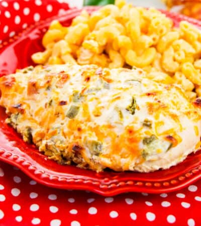 jalapeño popper chicken breast on a red plate with side of macaroni and cheese.