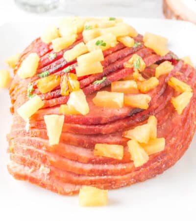 Pineapple Glazed Air Fryer Ham served on white platter topped with fresh pineapple