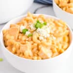 Buffalo Chicken Mac and Cheese in white bowl topped with blue cheese and scallions.