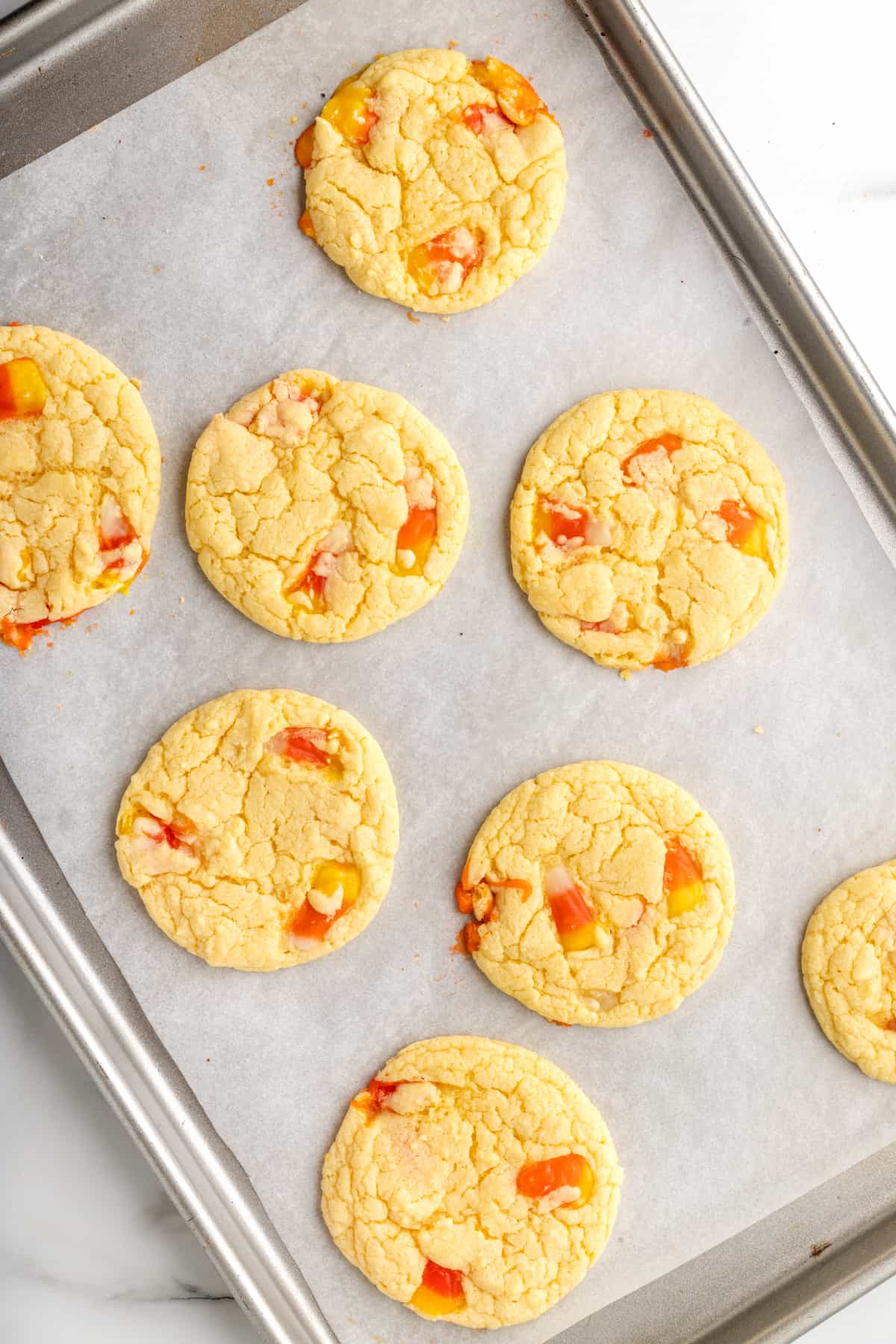Cookies with candy corn in them on parchment lined-baking sheet