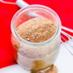 Homemade Chili Seasoning Mix in small glass jar with wire whisk next to it