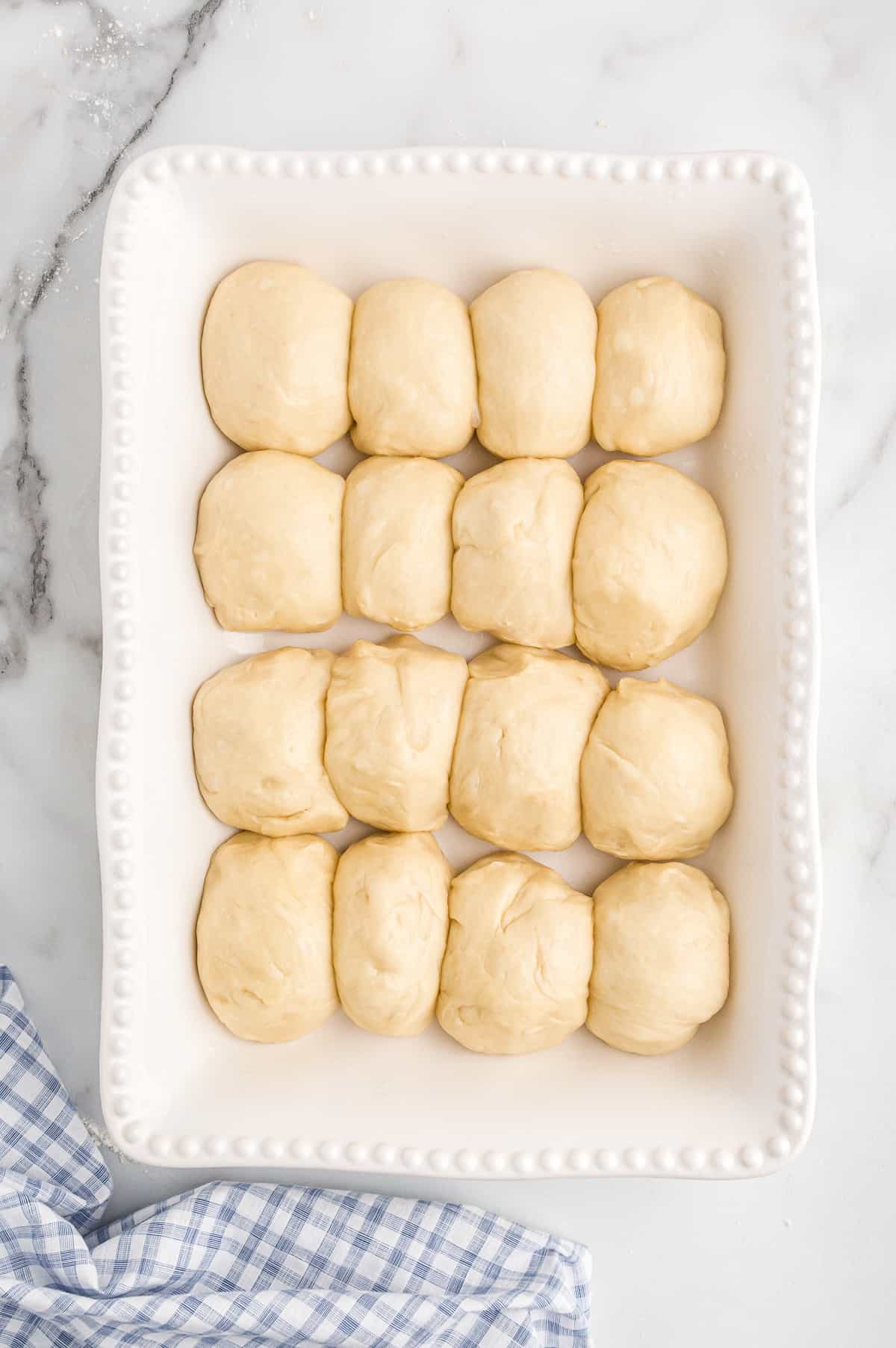 Unbaked potato roll buns in baking dish