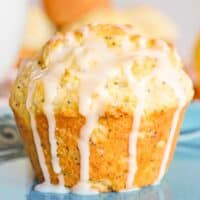 Lemon poppy seed muffin drizzled with lemon glaze which is dripping down the sides