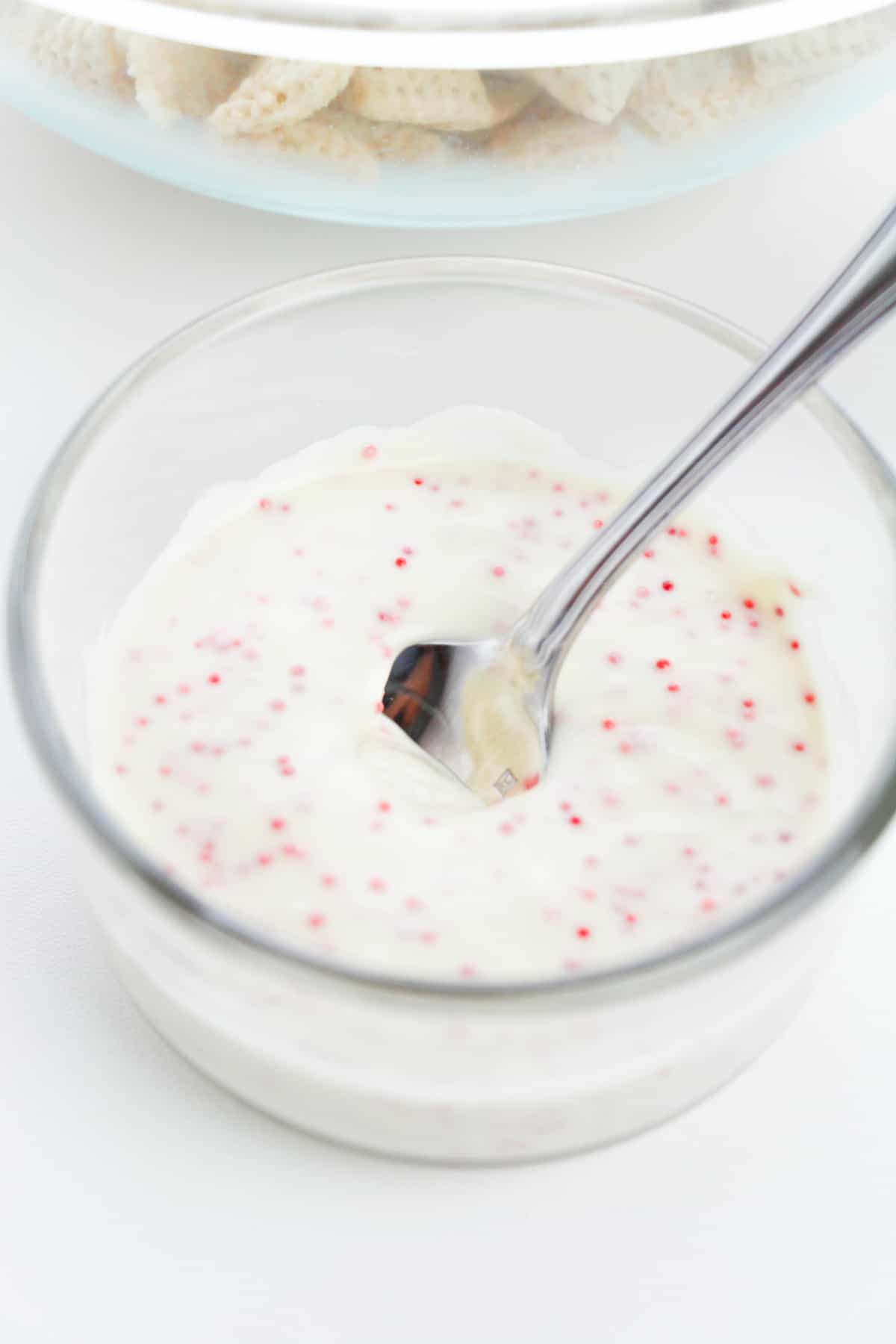 glass bowl with melted white chocolate with red specks in it
