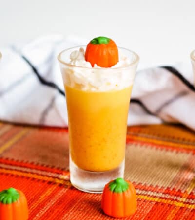 Pumpkin jello shot topped with whipped cream and candy pumpkin