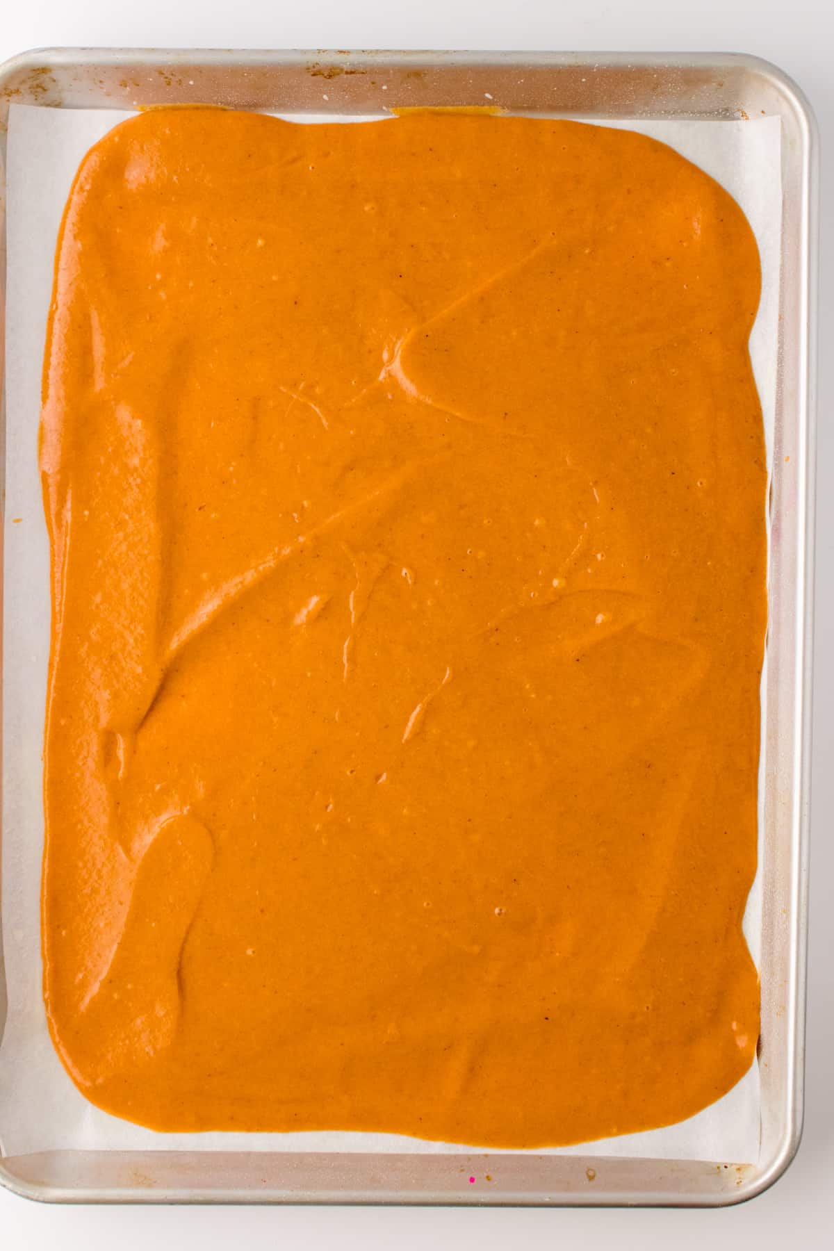 Pumpkin spice cake batter in baking sheet pan