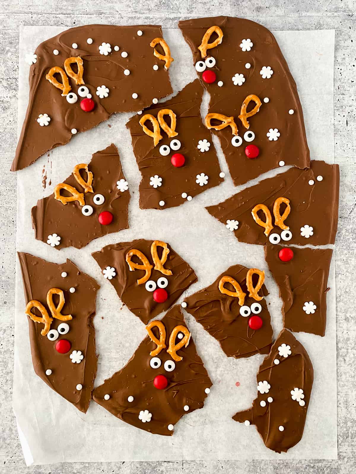 Reindeer Chocolate Christmas Bark broken into pieces on parchment paper