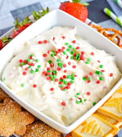 Christmas dessert dip served with christmas cookies, strawberries, and pretzels for dipping