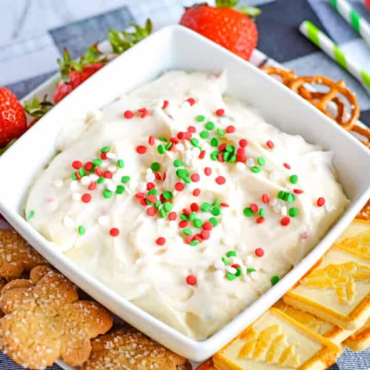 Christmas dessert dip served with christmas cookies, strawberries, and pretzels for dipping