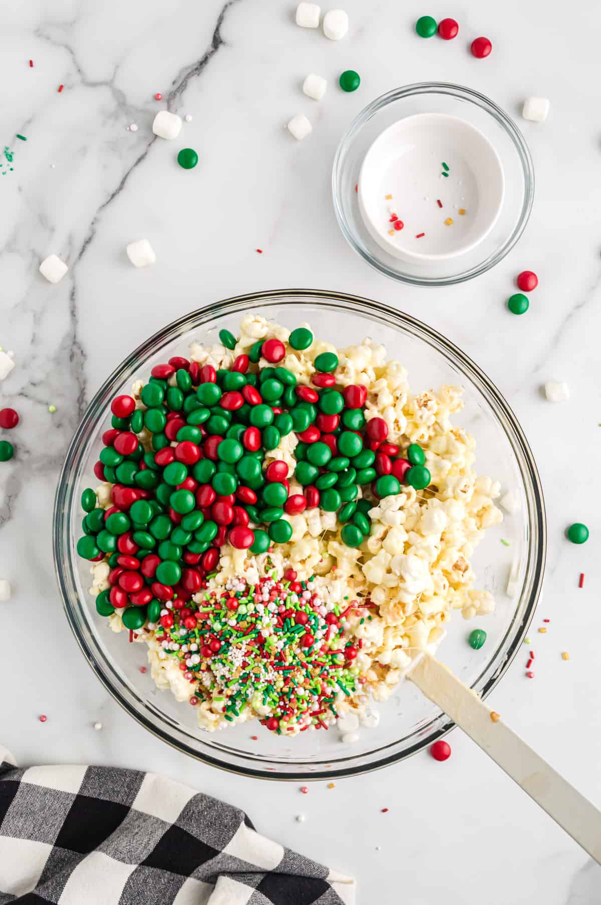 Christmas M&M candies and sprinkles added to sticky popcorn mixture