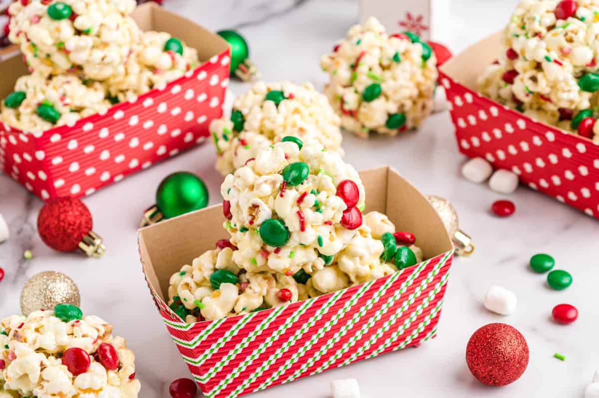 Christmas Popcorn Balls with M&Ms and sprinkles in paper gifting containers