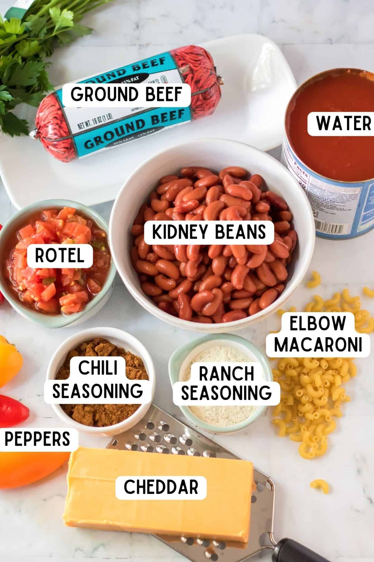 Ingredients for Chili Mac: kidney beans, ground beef, rotel, chili seasoning, ranch seasoning, elbow macaroni, bell peppers, water, and a black of cheddar cheese.