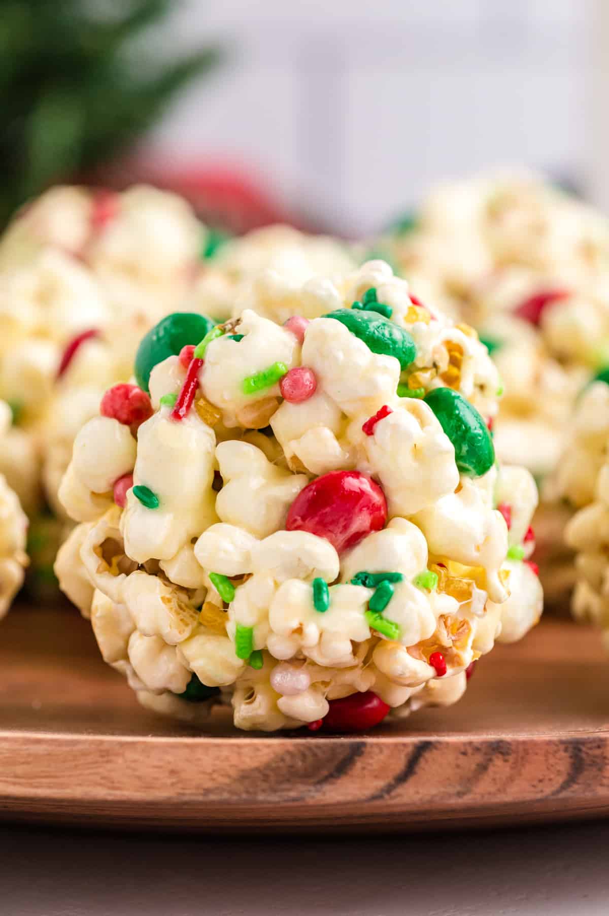 Close up of a popcorn ball with holiday sprinkles and M&Ms