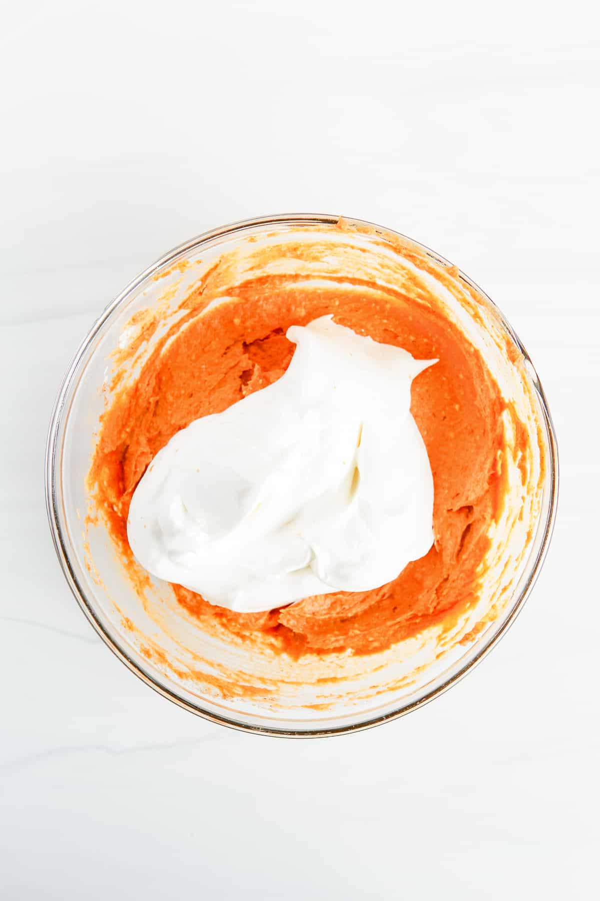 In process image of Cool Whip being added to pumpkin dip