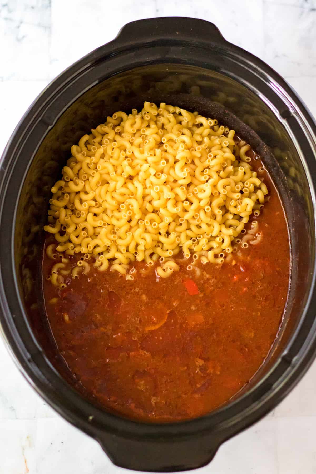 Elbow macaroni noodles added to crock pot.