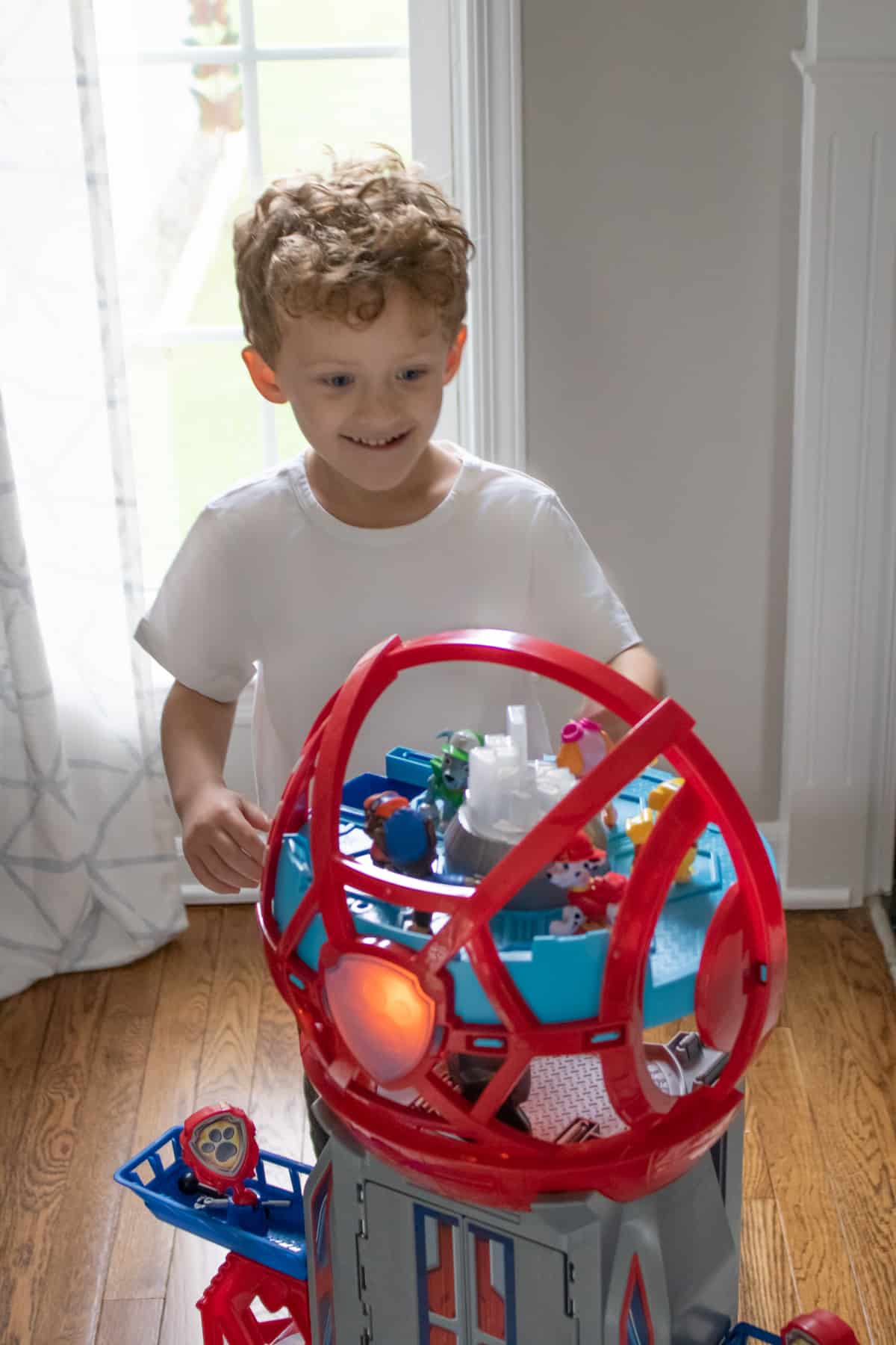 Boy smiling and playing with PAW Patrol tower playset