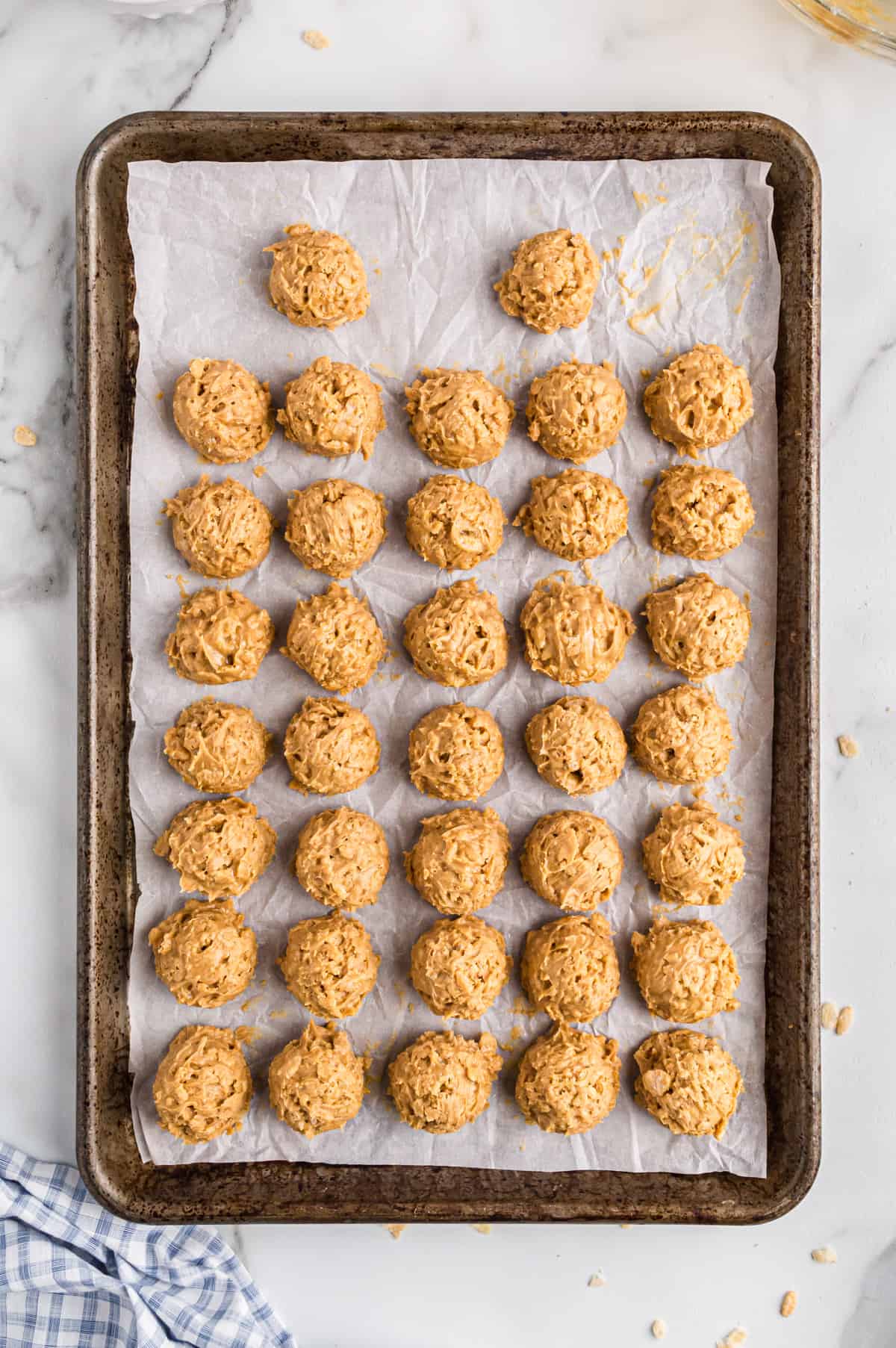 rice krisipie peanut butter balls on lined baking sheet