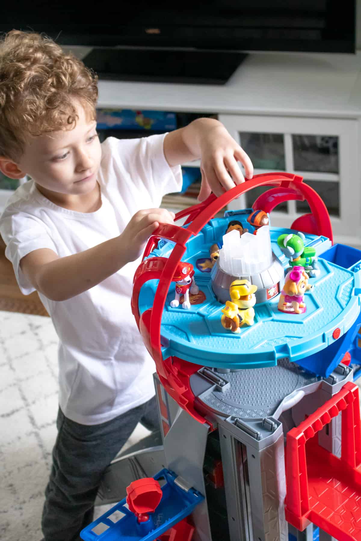 Boy setting up PAW Patrol figures in The Ultimate City Tower Playset
