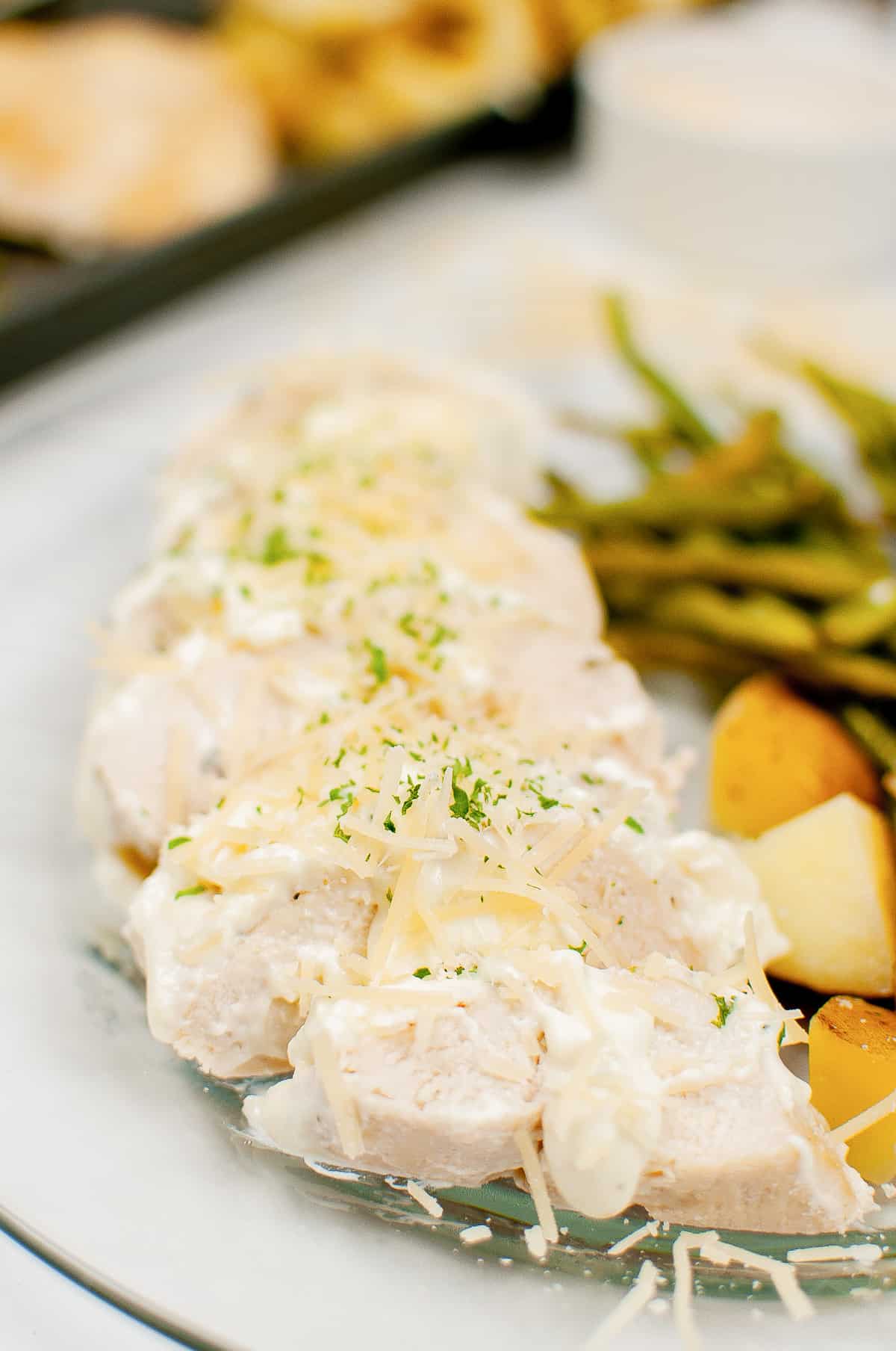 Creamy garlic chicken served with with green beans, potatoes, and topped with a creamy garlic sauce