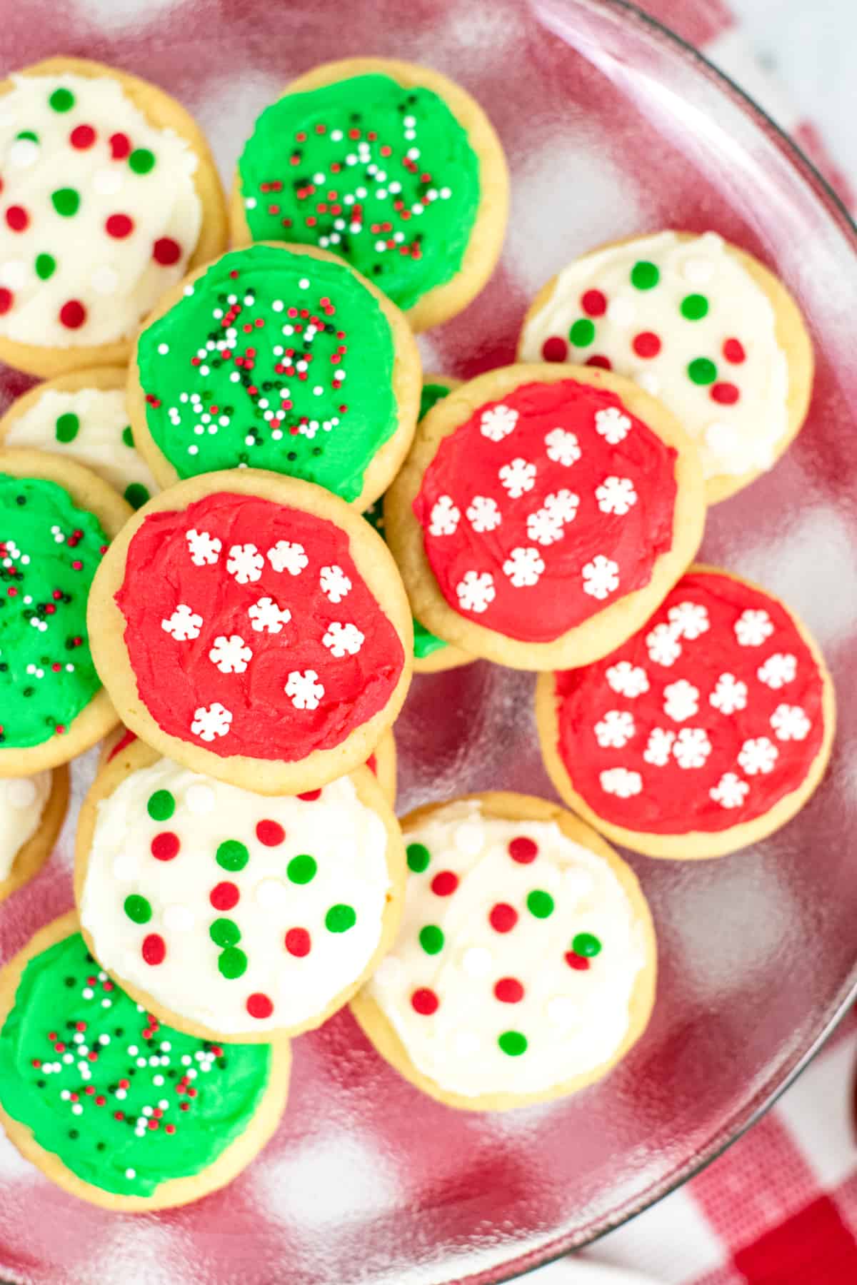 Platter of round cookies topped with either red frosting, green frosting, or white frosting and red, white, and green sprinkles