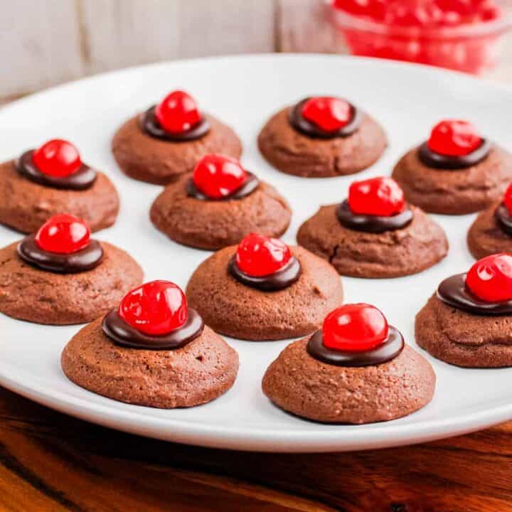 Chocolate cherry thumbprint cookies on white plate