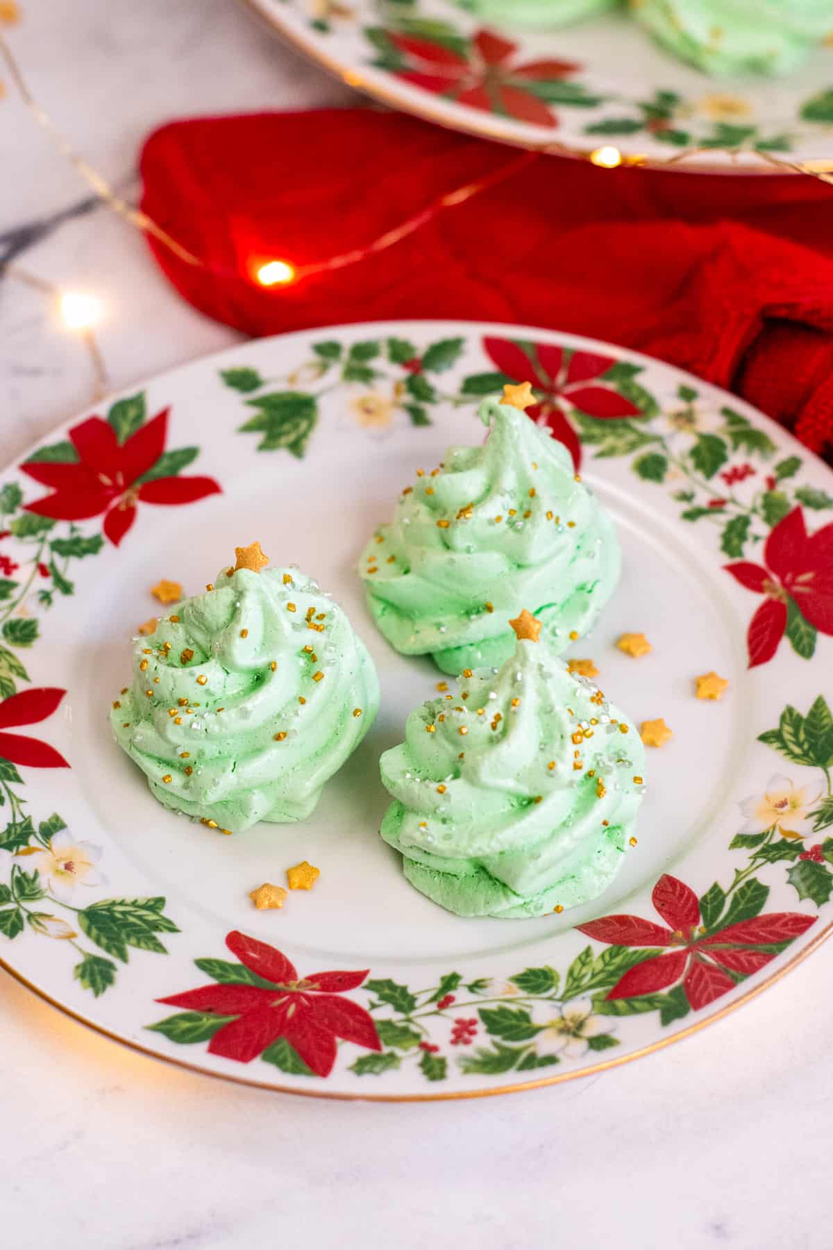 Meringue Christmas Tree Cookies on poinsettia plates.