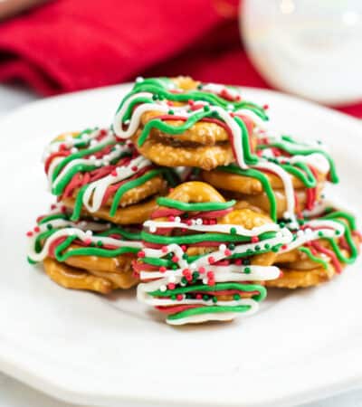 caramel pretzel bites drizzled with green, red, and white chocolate and topped with holiday sprinkles
