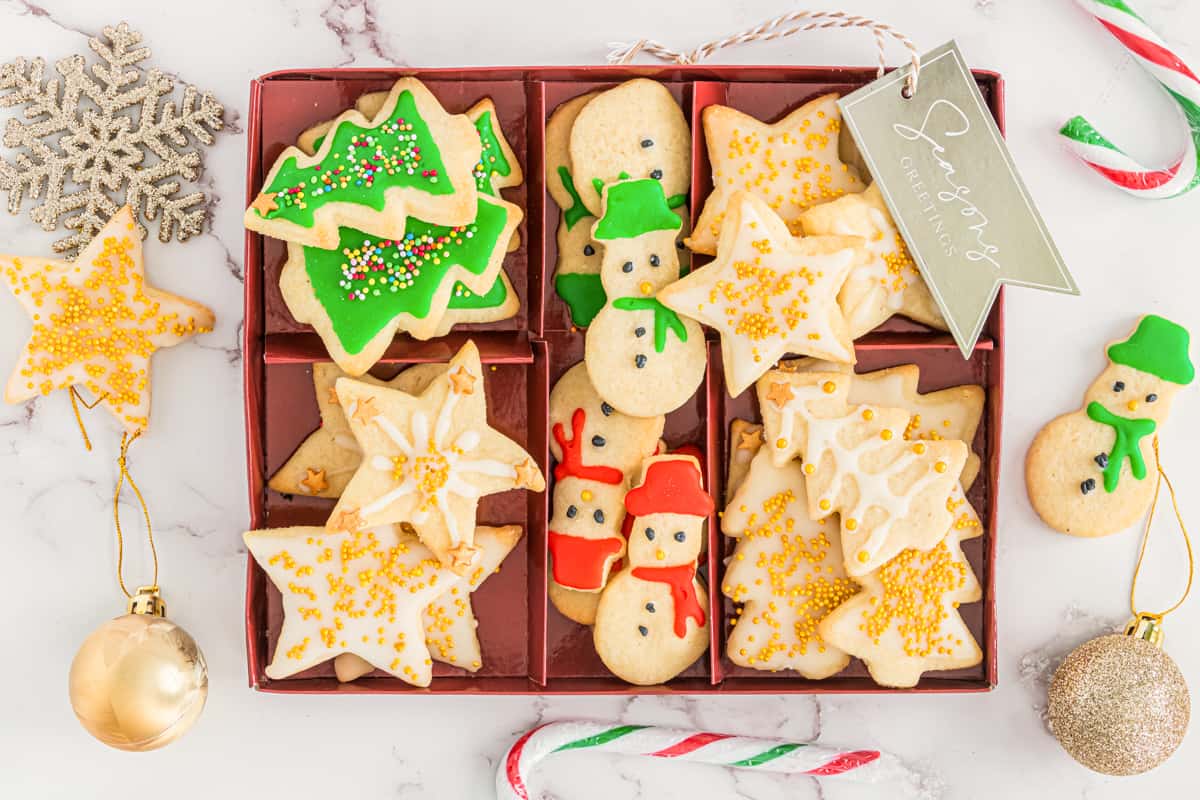 Christmas tree, snowman, and star shaped Cut out Christmas cookies arranged in serving box