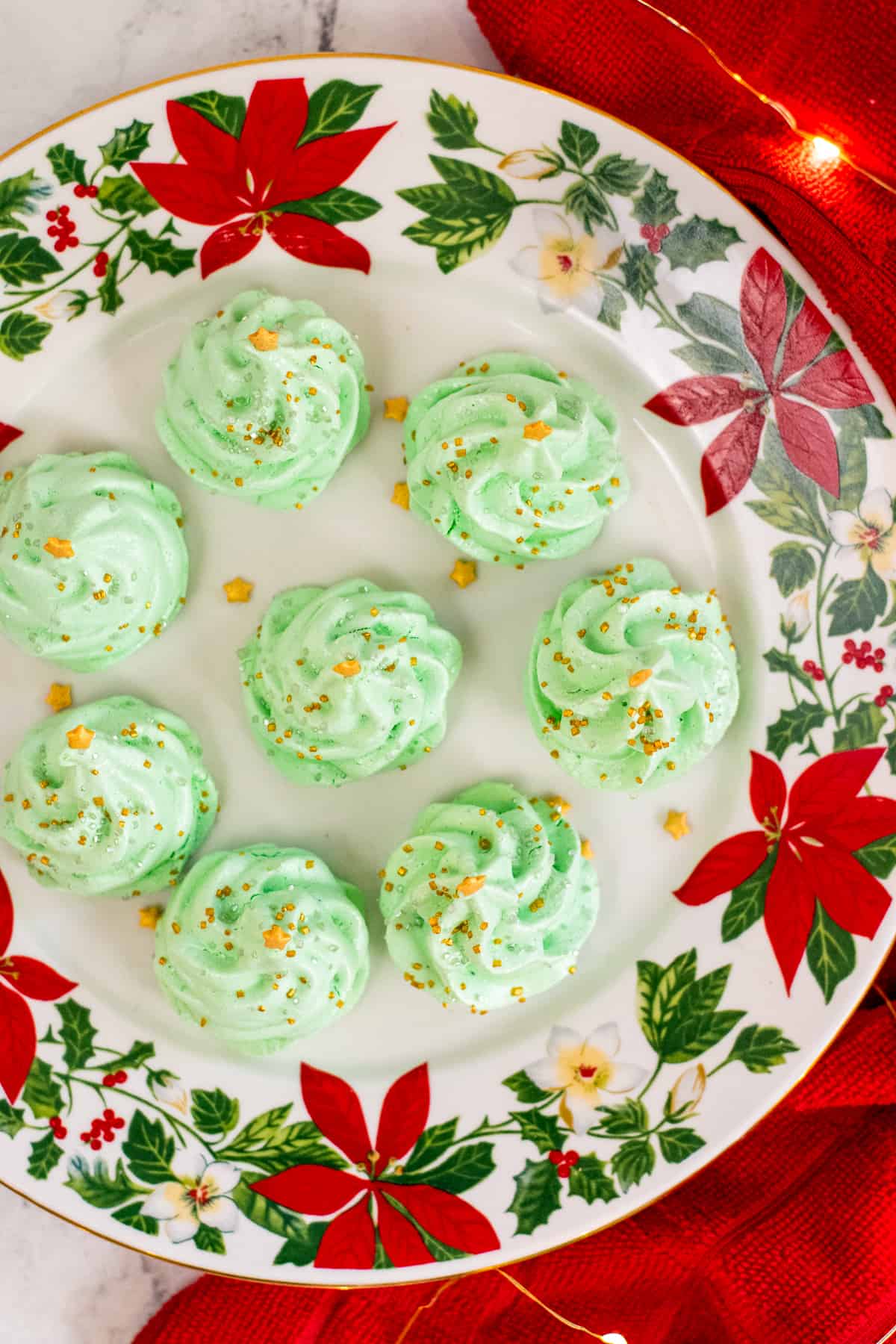 Top-down picture of 7 meringue christmas trees on christmas plate