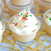 Christmas sugar cookie jello shot topped with whipped cream and red and green jimmies