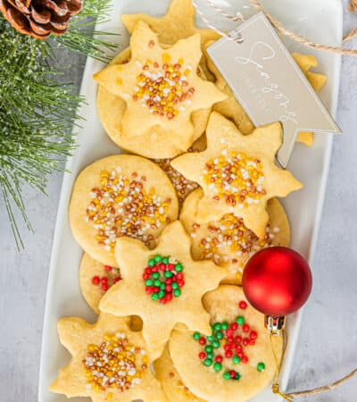 Christmas Shortbread Cookies cut in snowflake and circle shapes, and decorated with holiday sprinkles.