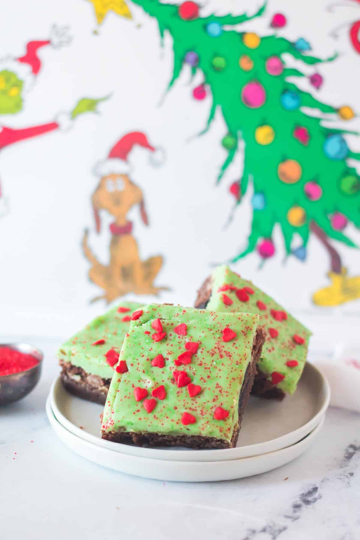 Grinch Brownies with green frosting and red heart sprinkles