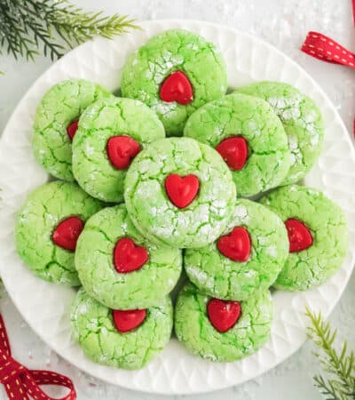 Grinch Cake Mix Cookies decorated with red heart candy in center