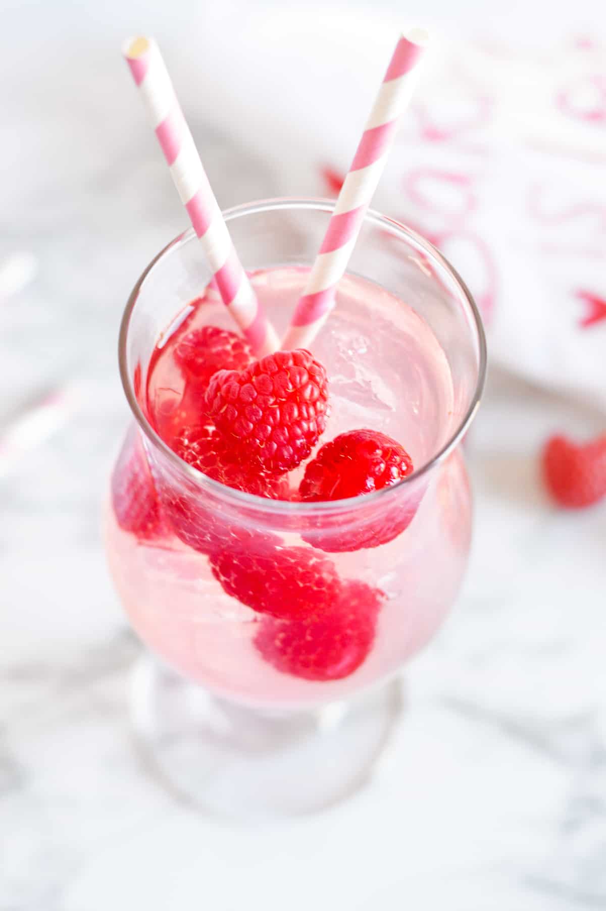 pink moscato sangria with fresh raspberries in cocktail glass