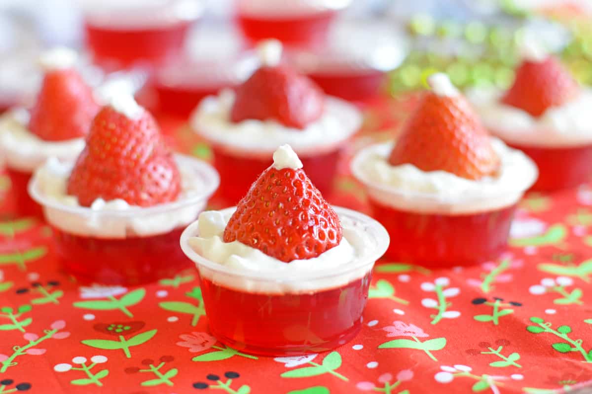 Strawberry Santa Hat Jello Shots made with strawberry jello, whipped cream, and fresh strawberries