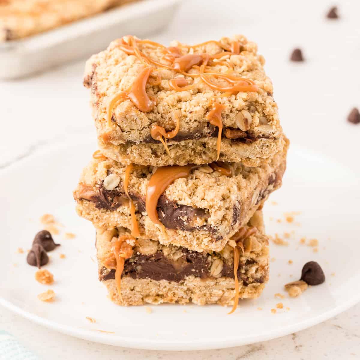 Carmelitas Cookies with sticky caramel oozing out sliced into squares and stacked on top of each other on a white plate