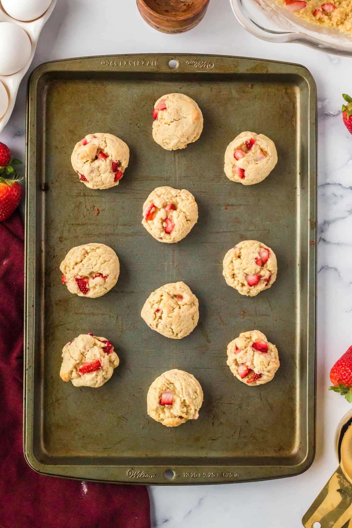 Freshly baked strawberry shortcake cookies on baking sheet