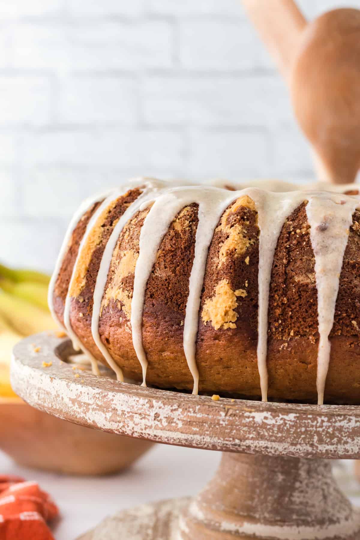 Golden brown banana bundt cake with brown sugar glaze dripping down the sides