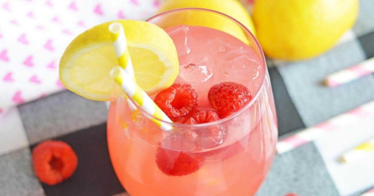 pink vodka lemonade cocktail with fresh raspberries and lemon garnish