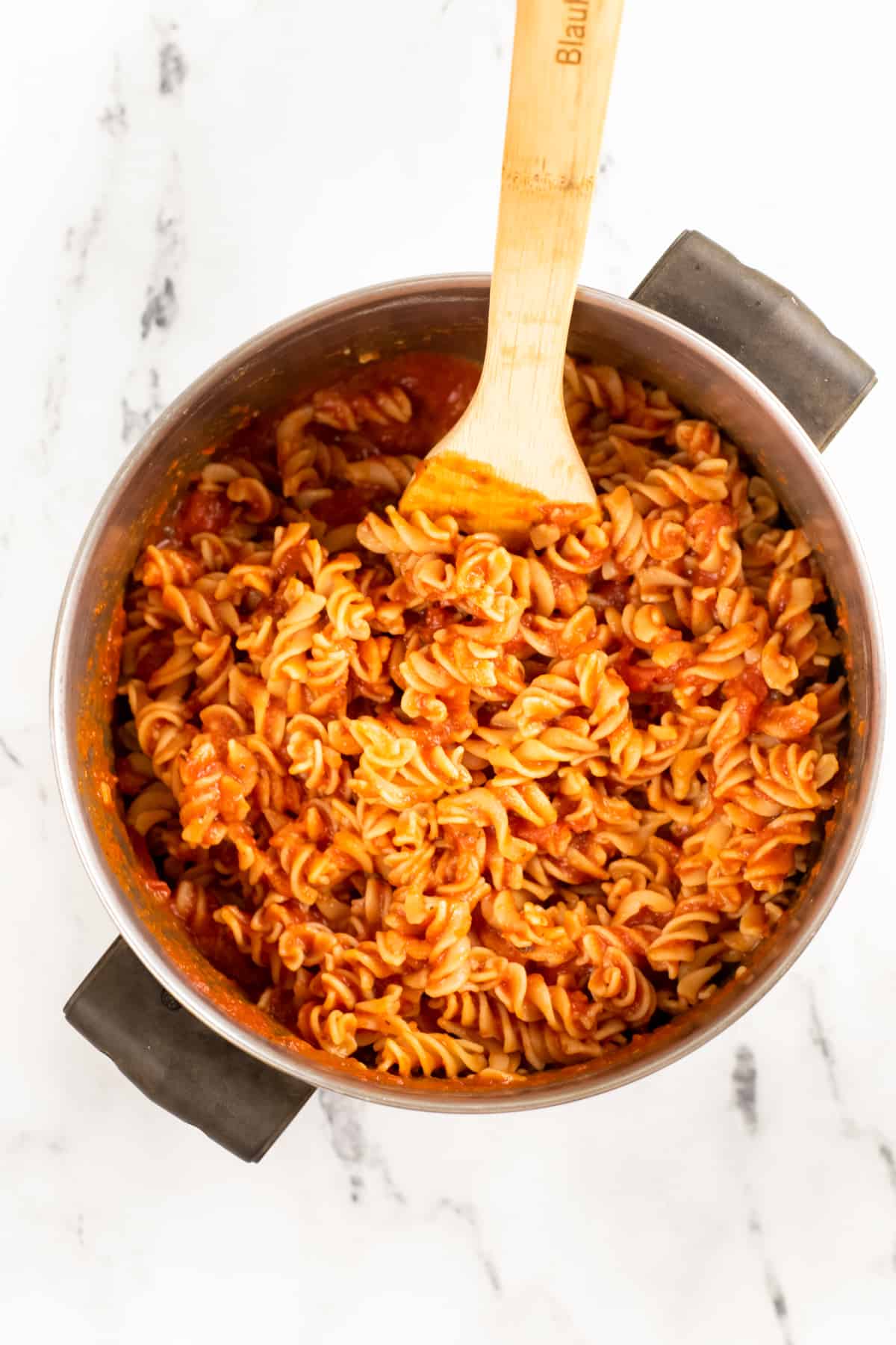 Cooked rotini pasta in red sauce in large pot