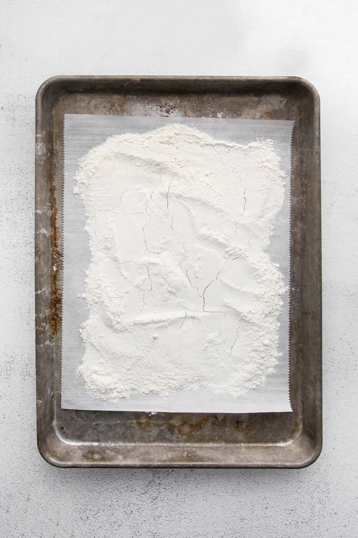 Flour spread on parchment-lined baking pan.